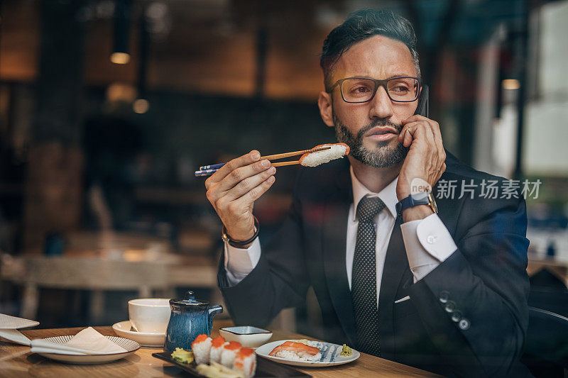 在寿司店打电话的男人