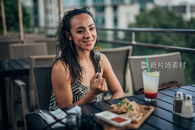 坐在餐馆外面吃午饭的女人