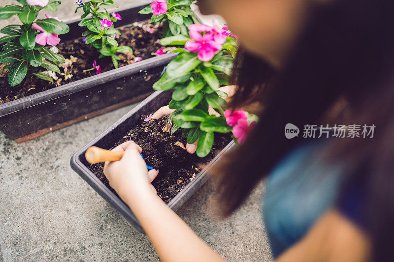 一个年轻女子在后院种花