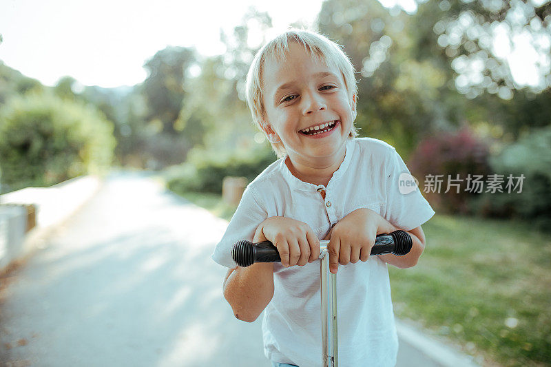 小男孩骑着滑板车