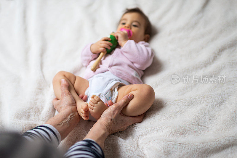 小婴儿接受骨科治疗她的腿，以防止髋关节发育不良的儿科理疗师