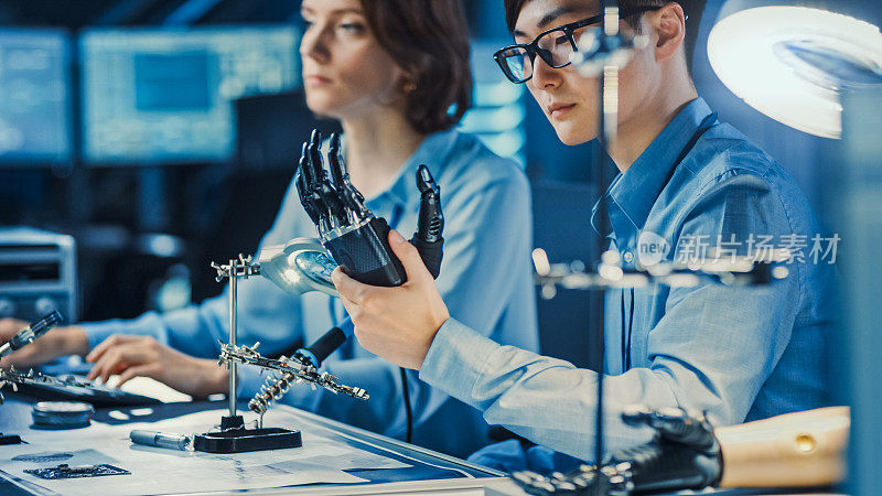 技术假肢机器人手臂是由两位专业开发工程师测试在一个高科技研究实验室与现代未来的设备。比较个人计算机上的数据。