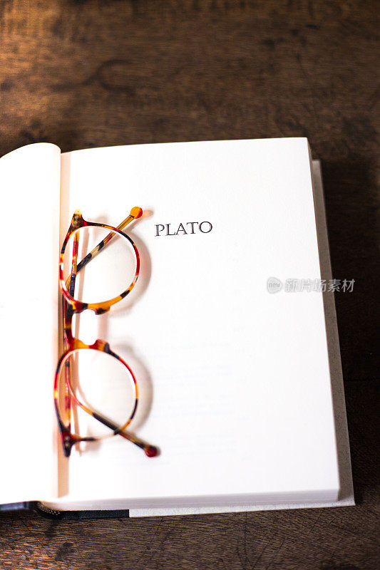 打开书，标题页:PLATO(带玳瑁眼镜)