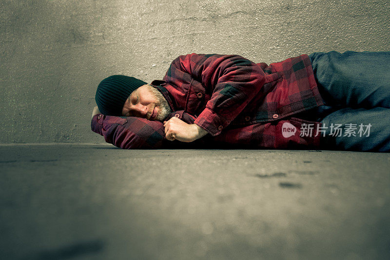 无家可归的年轻人躺在冰冷的地铁隧道里