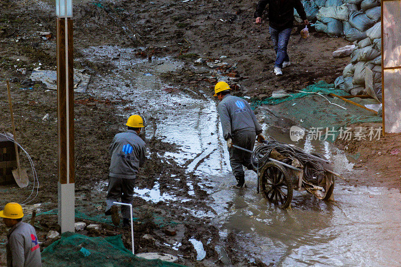 雨后农民工在北京的一个建筑工地工作