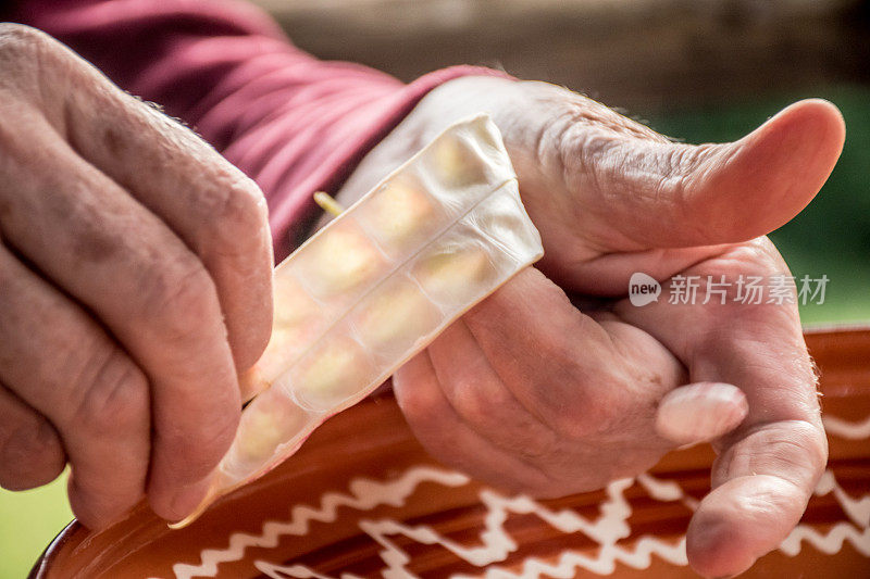 近距离观察高级女性手剥Borlotti豆壳