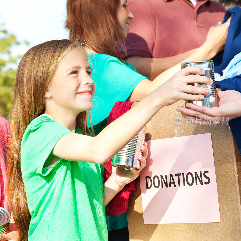 小女孩在食品捐赠活动中捐赠罐装食品