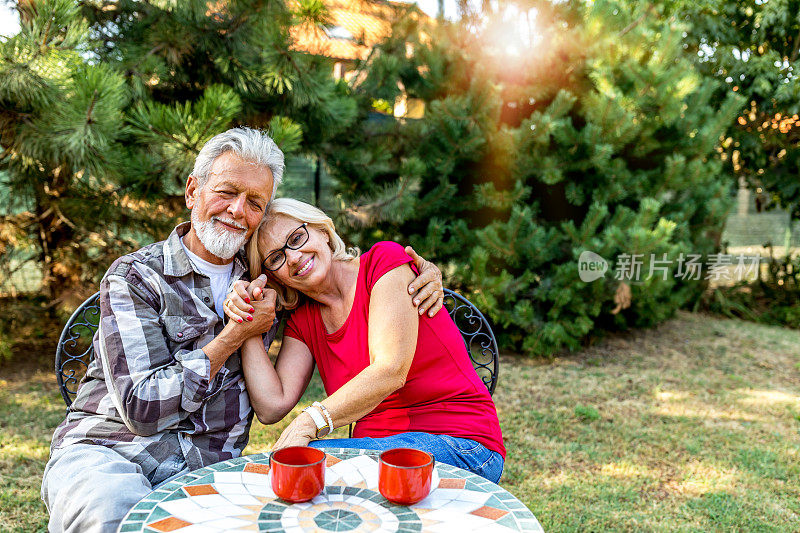 一对老年夫妇在户外享受清晨的咖啡