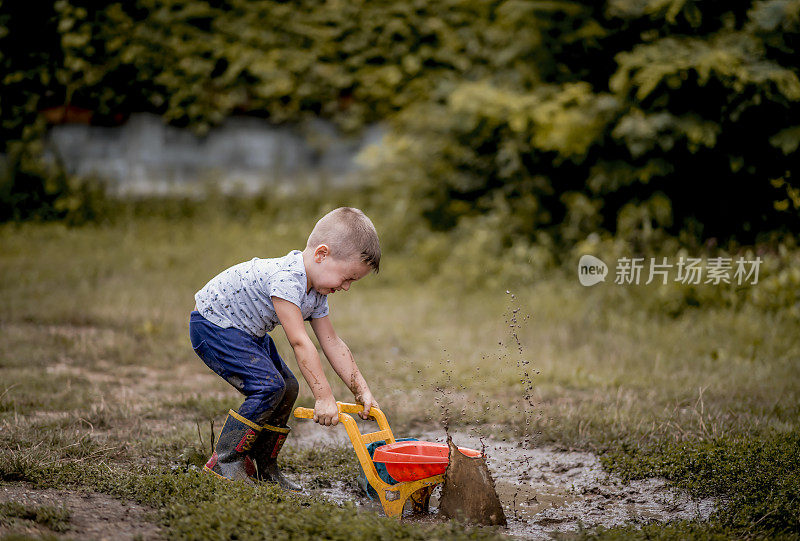 小男孩在泥里玩。