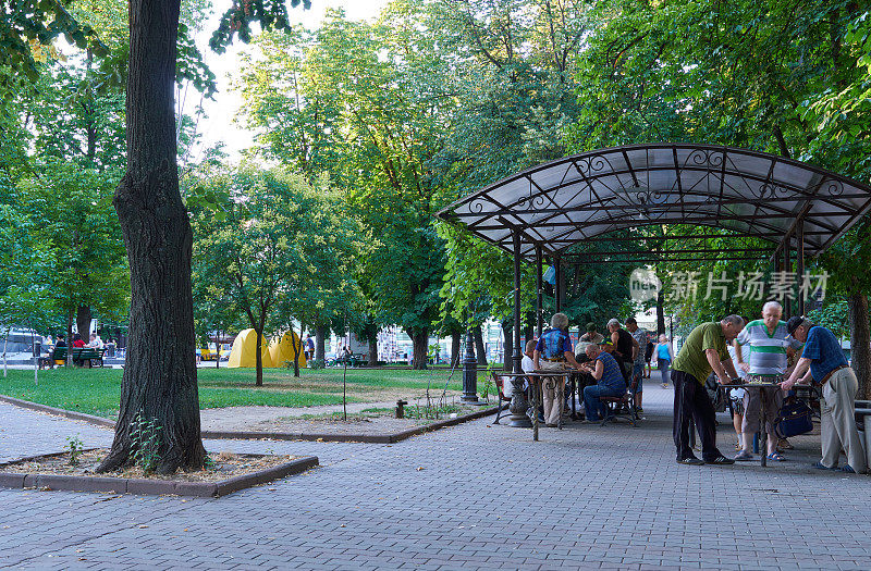 在城市公园的大教堂广场上，有凉亭与人们下棋和交流