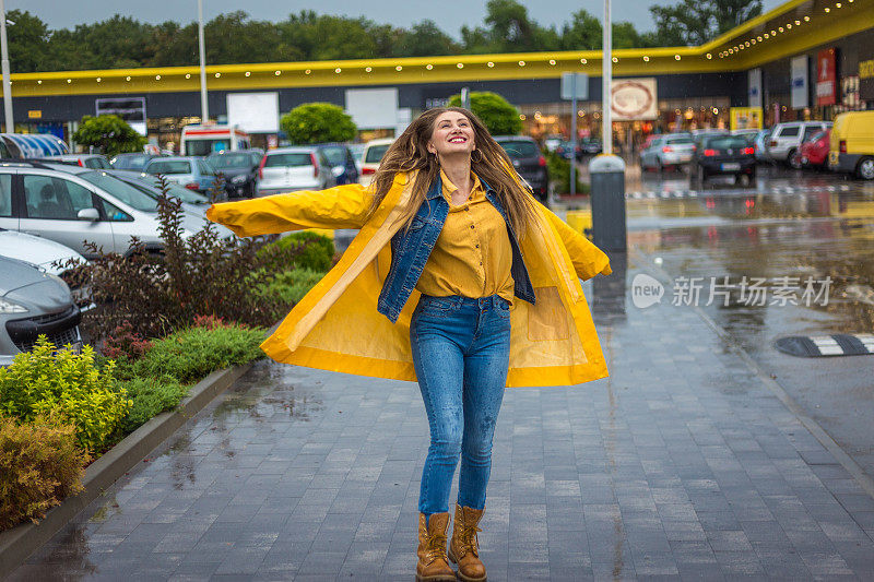 年轻女子快乐地在雨中跳跃