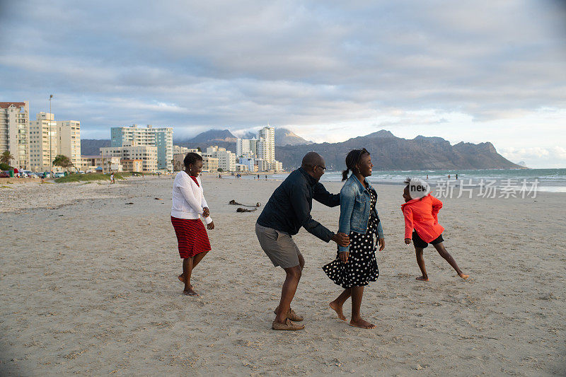 快乐的家庭一起在沙滩上玩接球