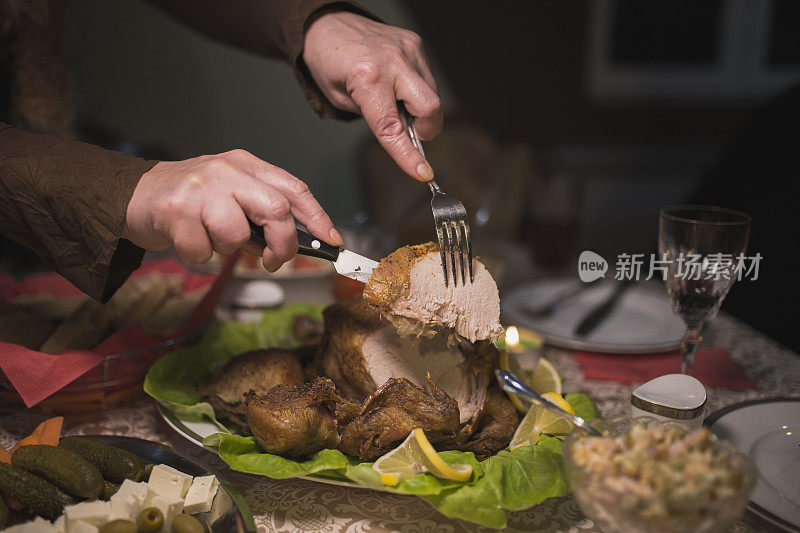 感恩节晚餐期间，妇女正在切烤家禽肉