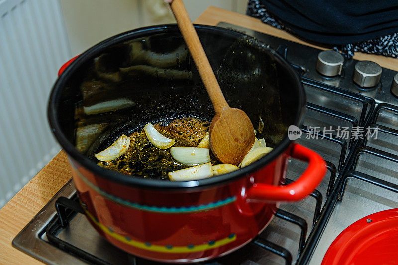 一位妇女正在准备一碗蔬菜汤，并用木勺搅拌配料。