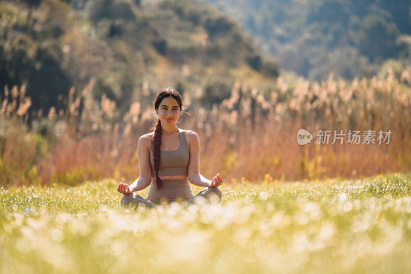 年轻的亚洲女人练习瑜伽和冥想在自然