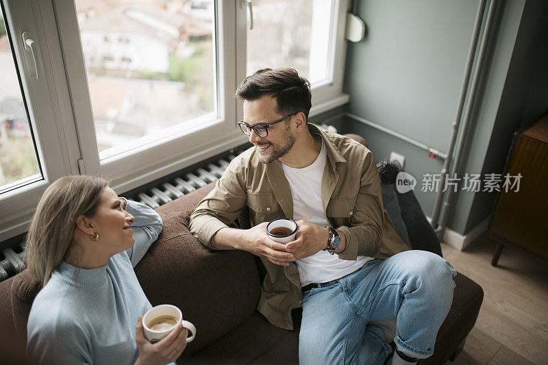 高角度的一个幸福的年轻白种人夫妇享受一杯咖啡在家里