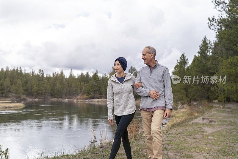 一位身患癌症的充满希望的女士和她的父亲一起悠闲地散步