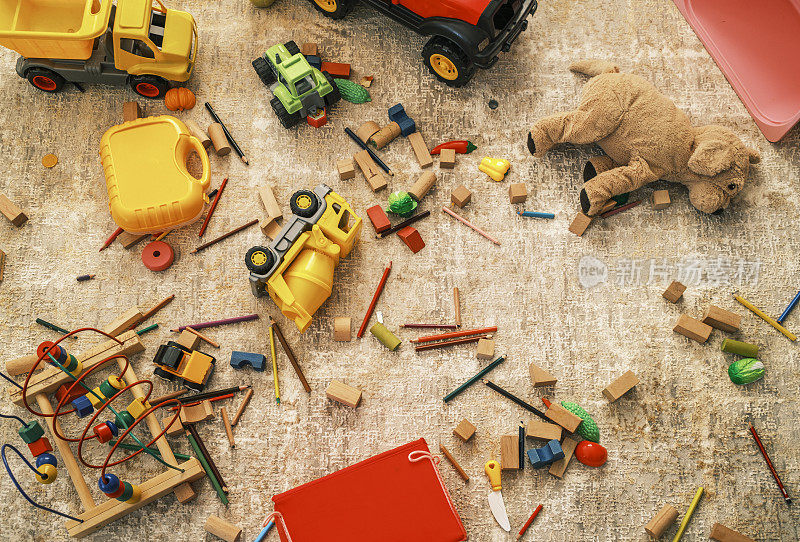 家里的地毯上散落着许多彩色钢笔和玩具