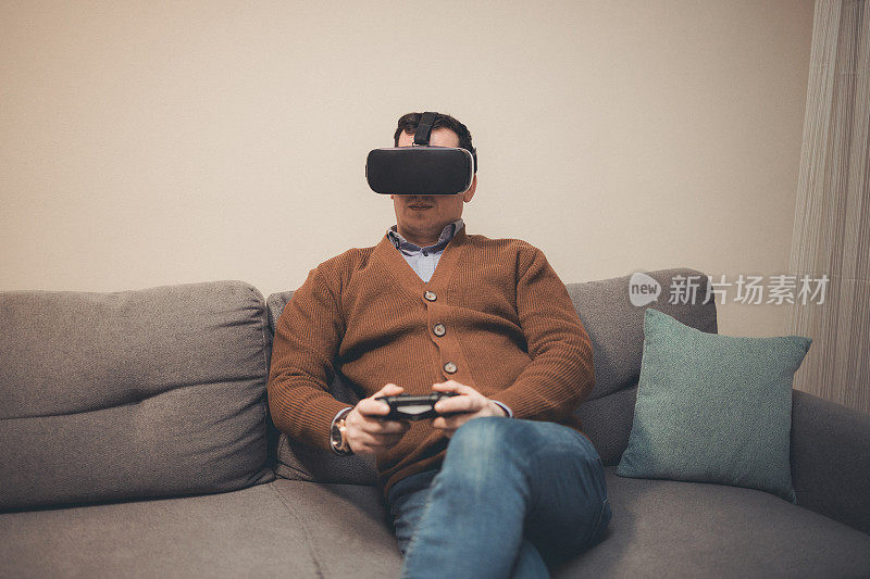 一名男子在家用VR和手柄玩视频游戏