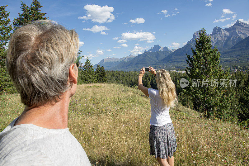 成熟的夫妇拍摄森林和山脉