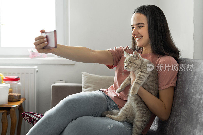 快乐的女人和她的猫在家里自拍