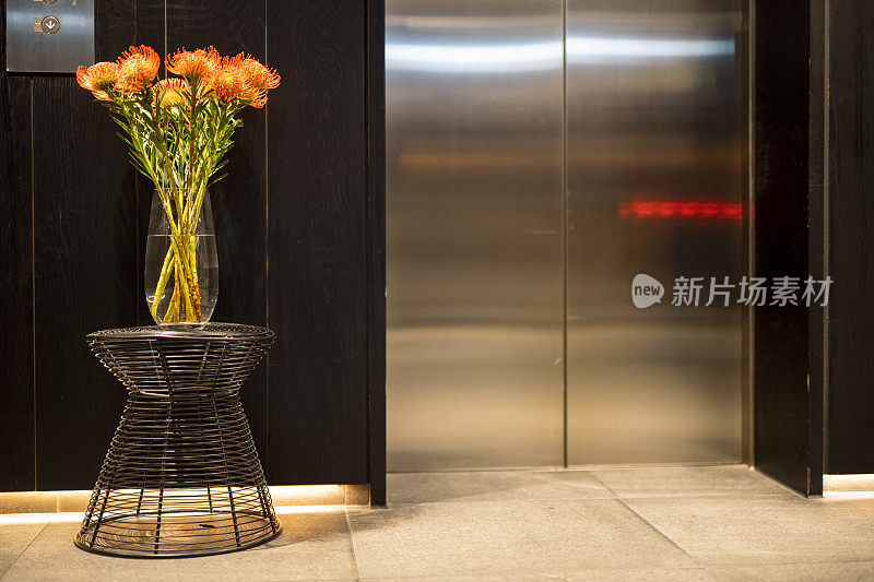 豪华酒店大堂美丽的protea花，电梯门关闭
