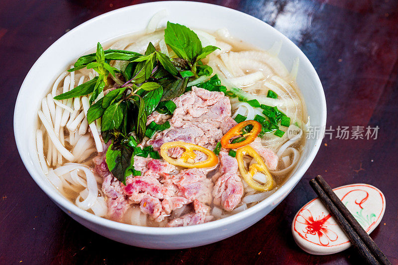 越南河粉汤，牛肉和米粉放在桌子上，特写。越南当地的餐馆。