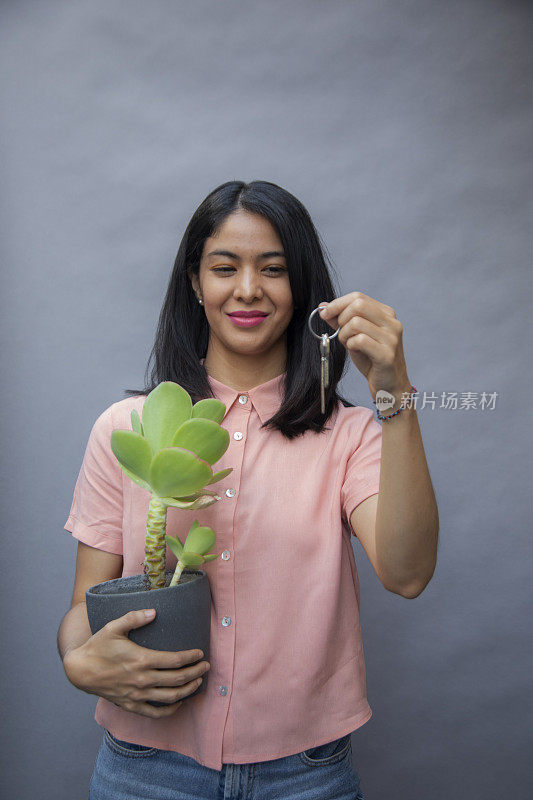 女人拿着植物和钥匙