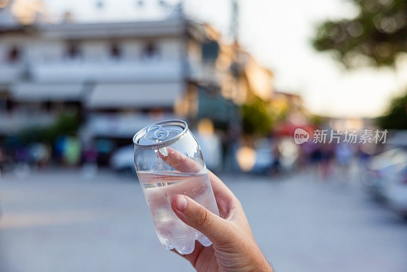 不认识的女人拿着装着水的塑料罐