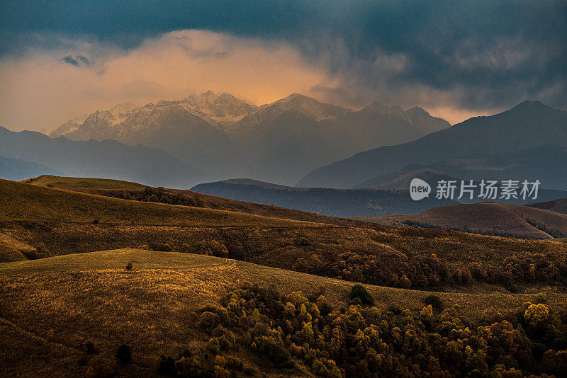 从俄罗斯厄尔布鲁斯地区的冈巴什山口，欣赏山脉山脊和山谷的壮丽日落