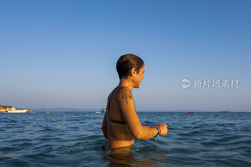 美丽的女人在海里游泳