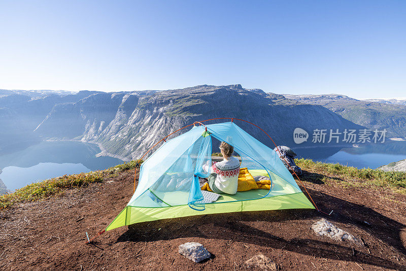 女人在帐篷里看美丽的全景