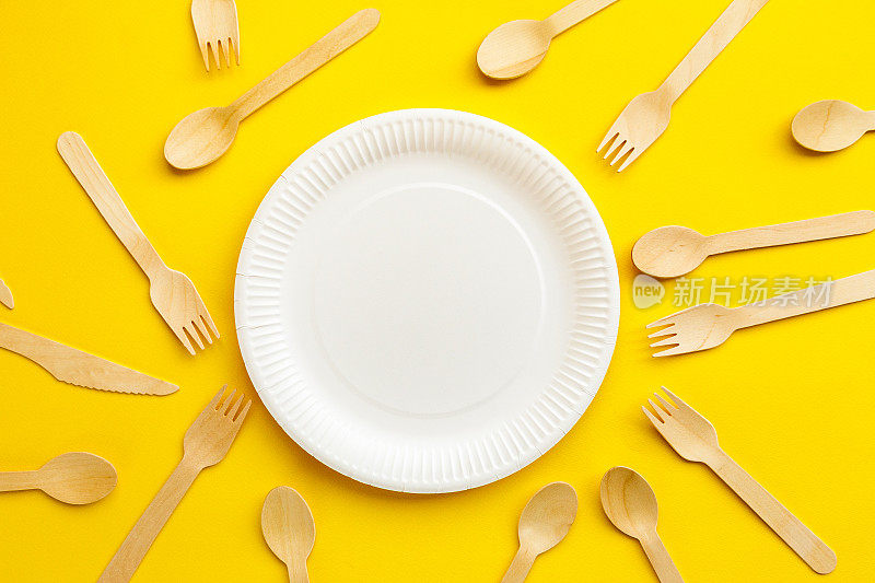 环保可回收的木制餐具和黄色背景的纸盘