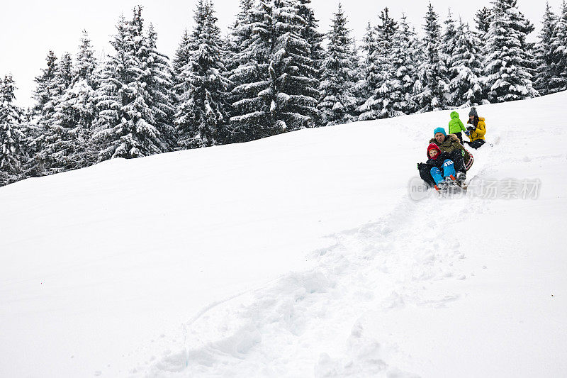 一家人带着两个孩子在雪地里享受美好的一天