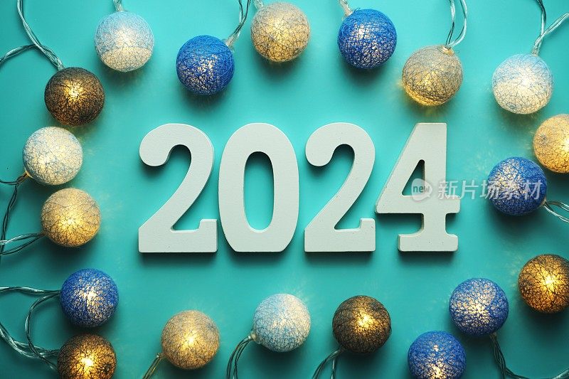 新年快乐2024字母与棉球LED装饰在蓝色背景