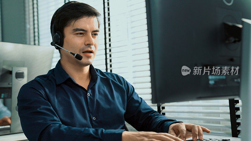 年轻能干的亚洲男性呼叫中心代理在办公室工作。