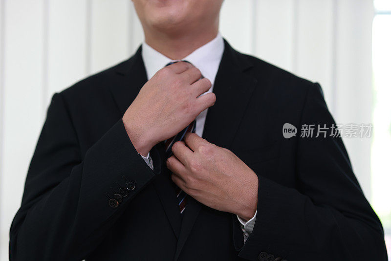 白领调整领带，男士整理领带。商人纠正领带