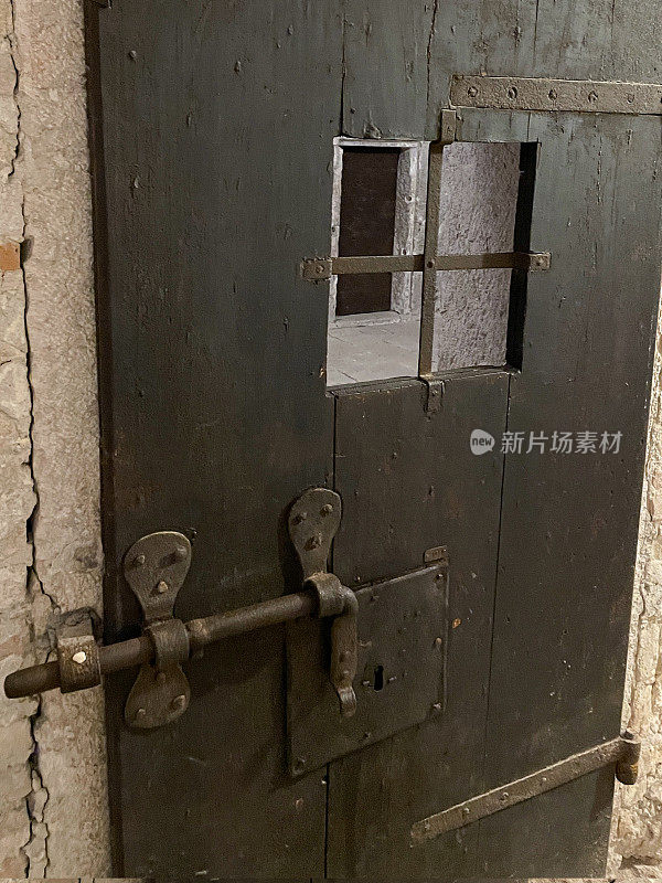 古代重木门的形象，带有生锈的金属门闩，手柄锁孔，安全机构，前景的焦点
