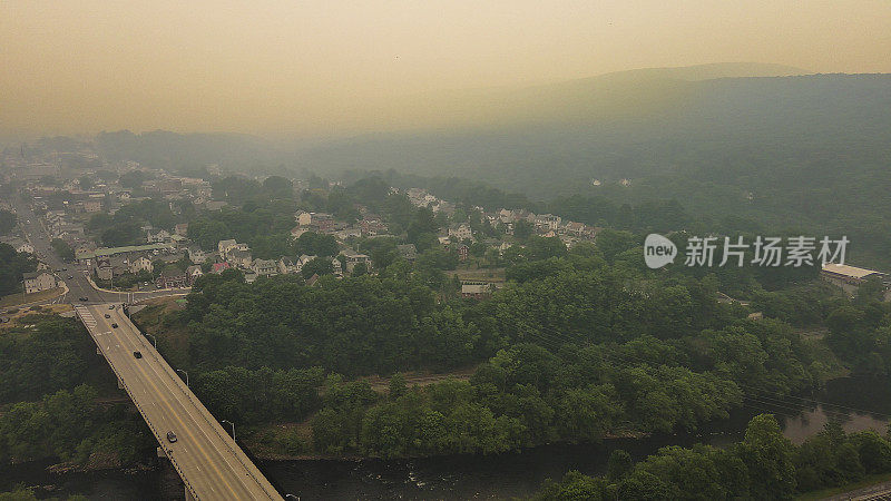 被野火烟雾笼罩的城镇高速公路:在宾夕法尼亚州波科诺斯阿巴拉契亚山脉吉姆索普，高架公路蜿蜒穿过被附近野火烟雾笼罩的山谷。空中争夺