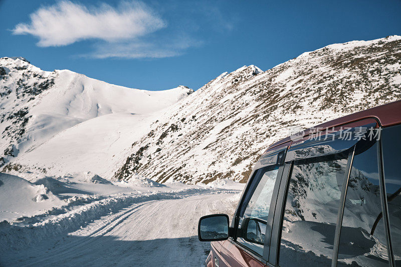 在一个阳光明媚的冬日，汽车正沿着雪道从川阿寿山口驶下