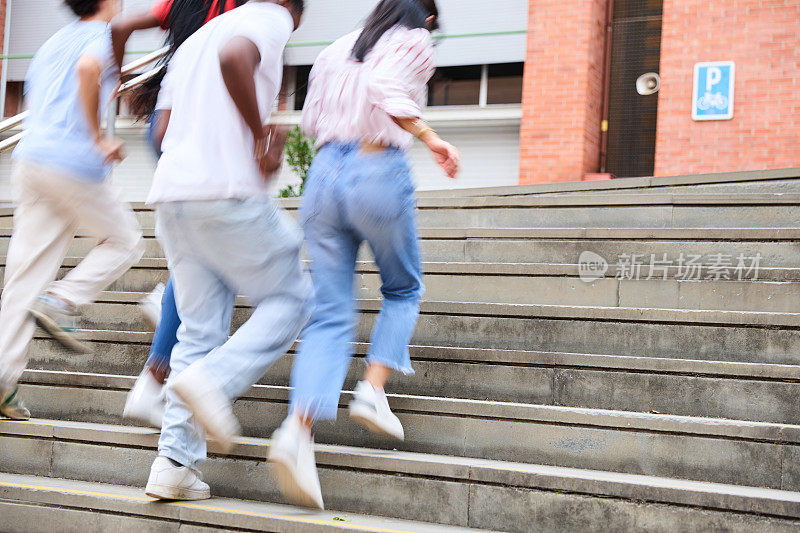 一群无法辨认的年轻学生跑上学校的楼梯