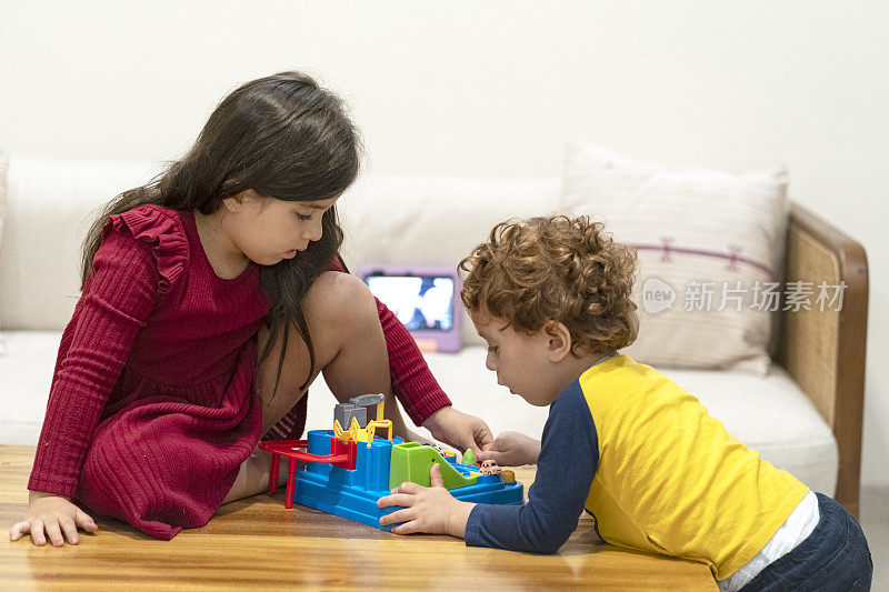 兄弟姐妹在玩玩具，背景是数码平板电脑