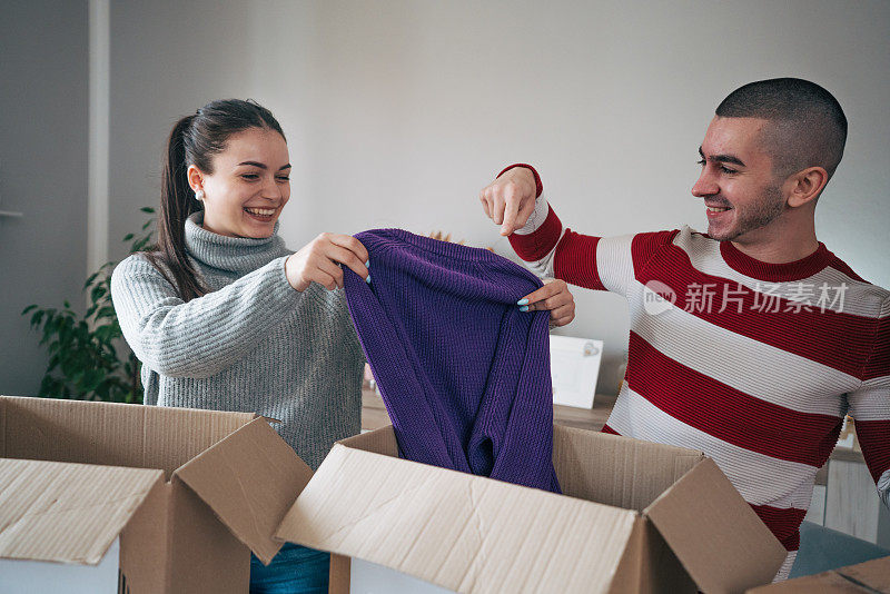 一对年轻夫妇正在为慈善机构收拾衣服