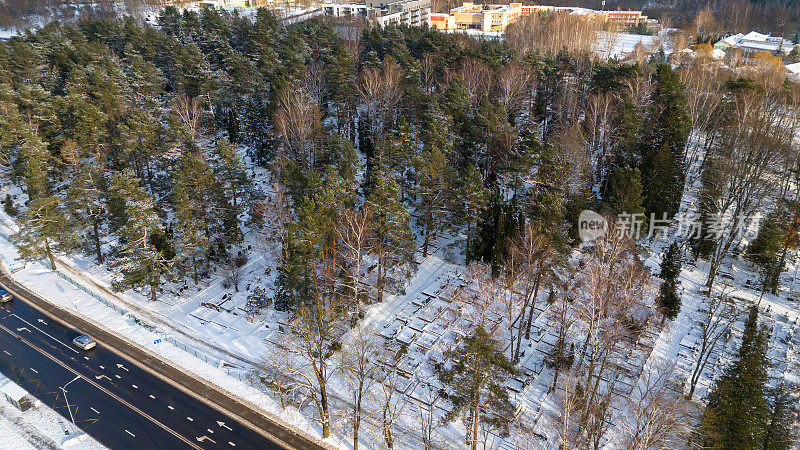 无人机拍摄的一个大墓地在森林覆盖雪在冬天的一天