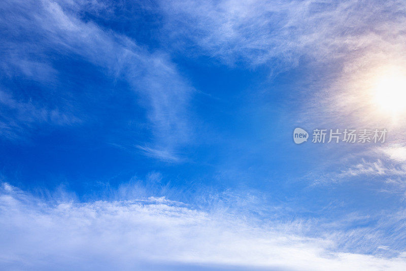 层层叠叠的羽状白云在蓝天和温暖的阳光下
