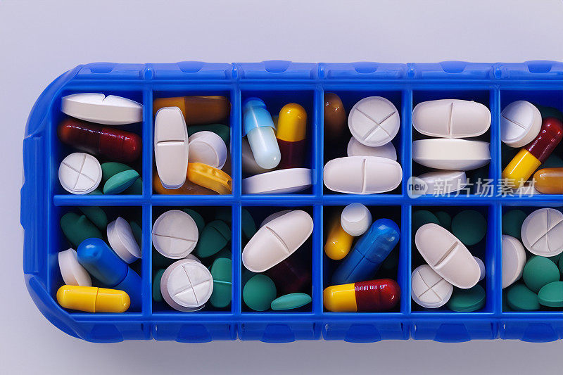 一堆白色、蓝色和其他颜色的药片。塑料包装的药丸。医疗保健和医学的概念