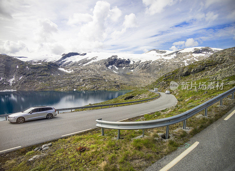挪威的Geiranger空中步道观景台，背景是雪山，车流蜿蜒而上
