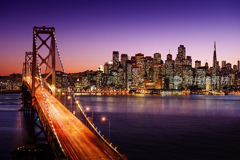 海湾大桥和日落时的旧金山天际线