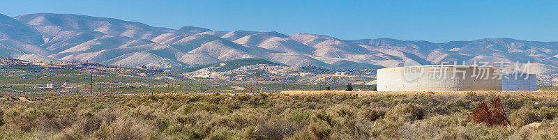 加州中部沙漠山脉和油罐的全景