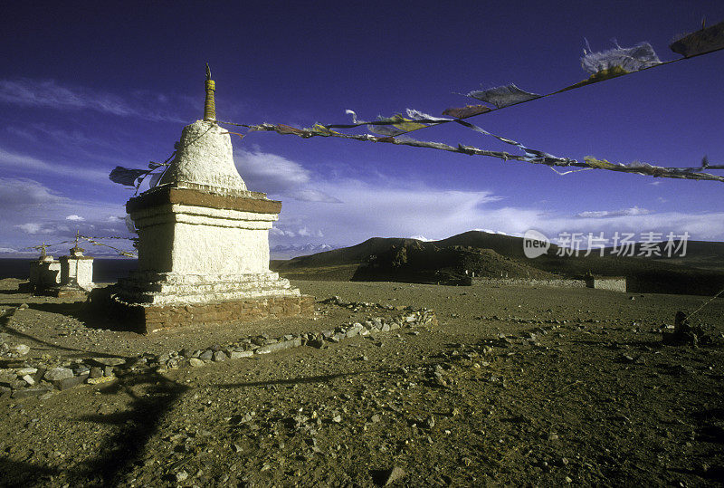 西藏西部玛旁雍罗湖上挂着经幡的佛塔